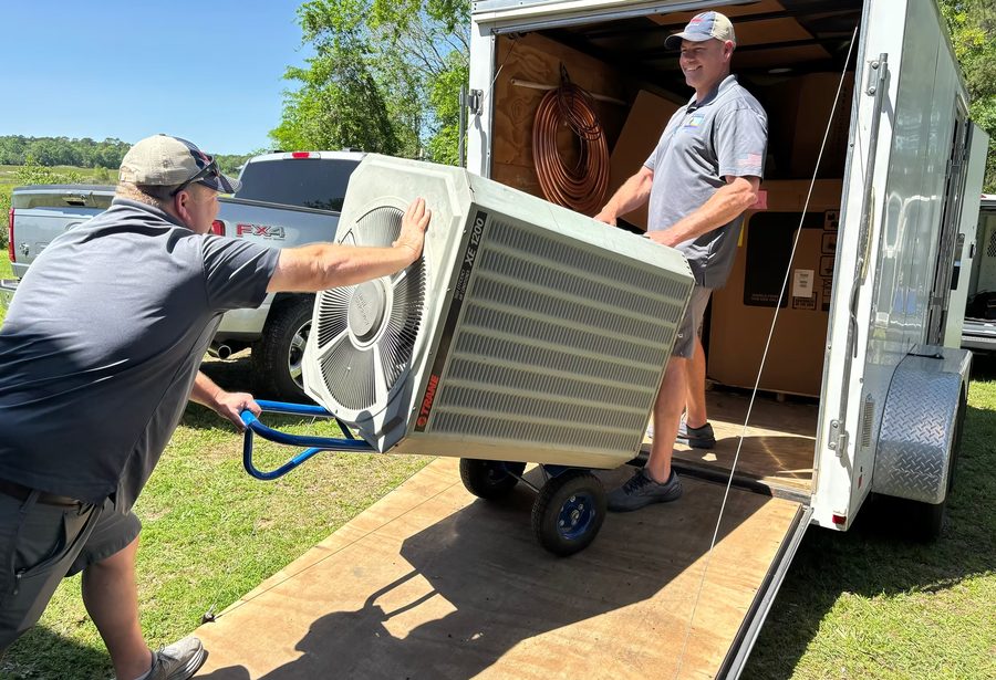 EverCool technicians unloading HVAC equipment from a service trailer ahead of an installation